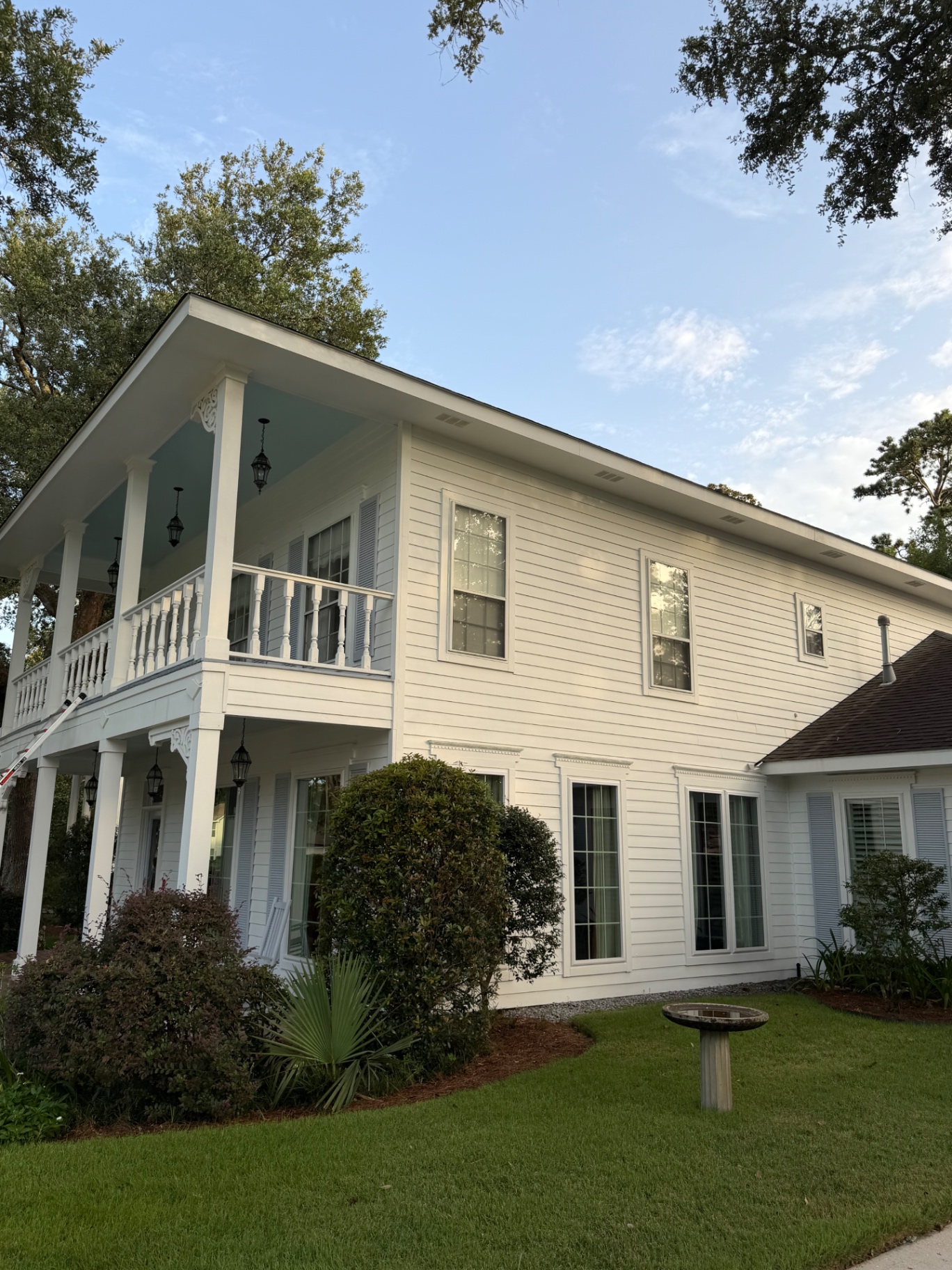 Wild West Washing technician soft washing a Louisiana home exterior